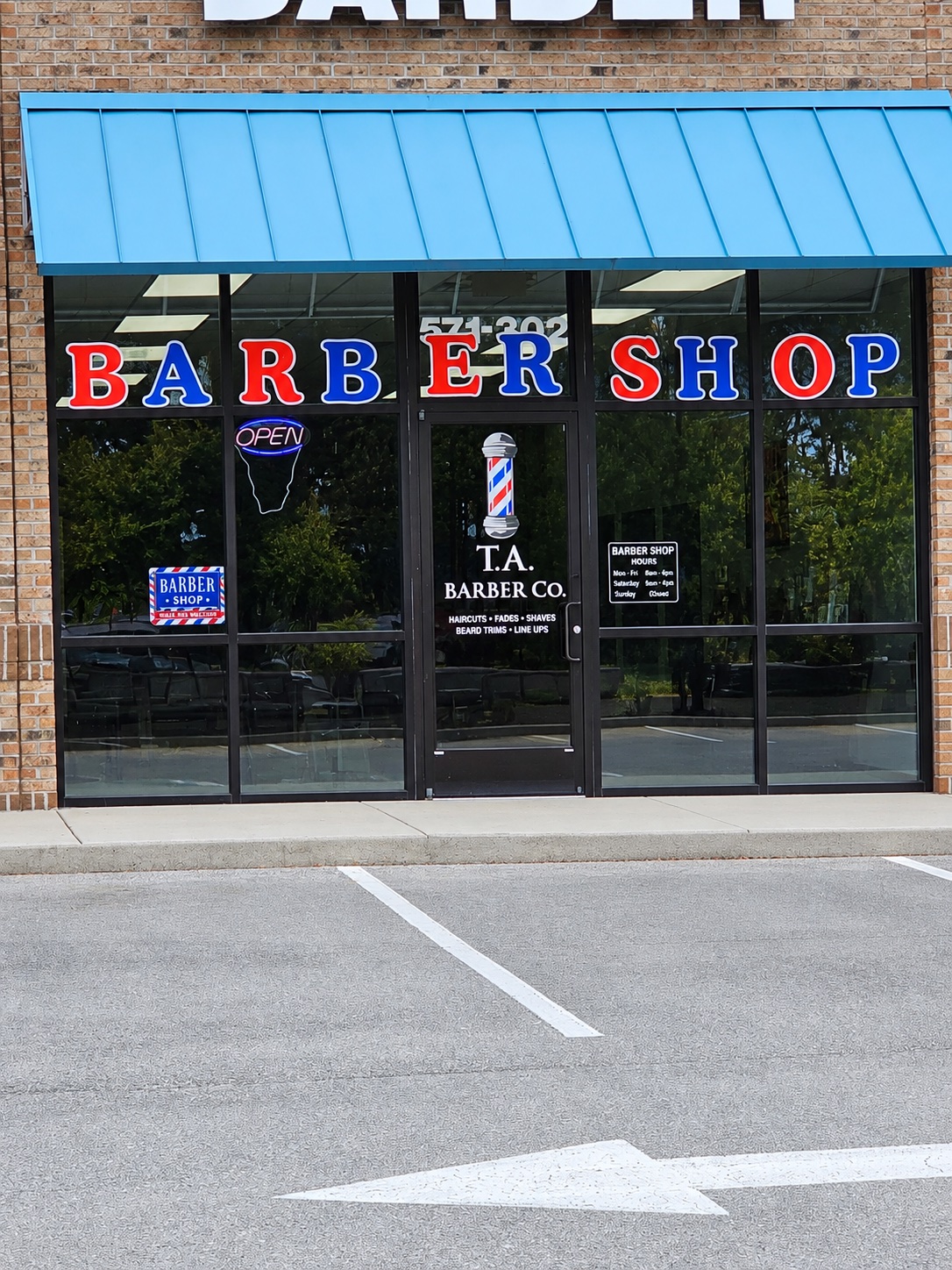 Actual TA Barber Co storefront, with barber lettering and entrance at Suite 302